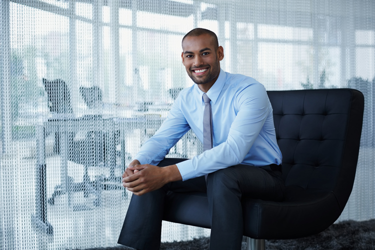 Smiling businessman sitting on chair with hands crossed